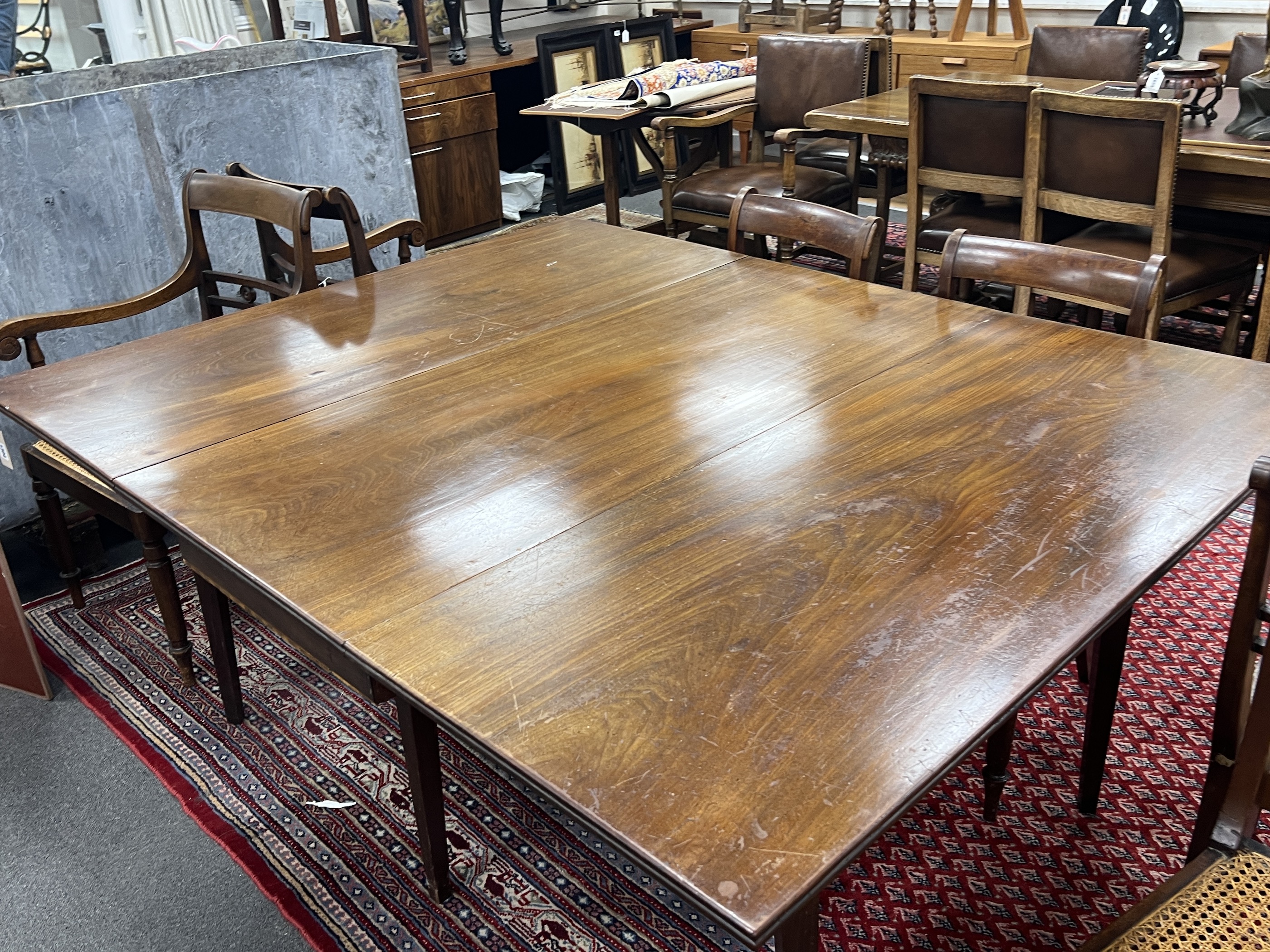 A George III mahogany drop leaf extending dining table on square tapered legs, 165cm extended, depth 130cm, height 74cm